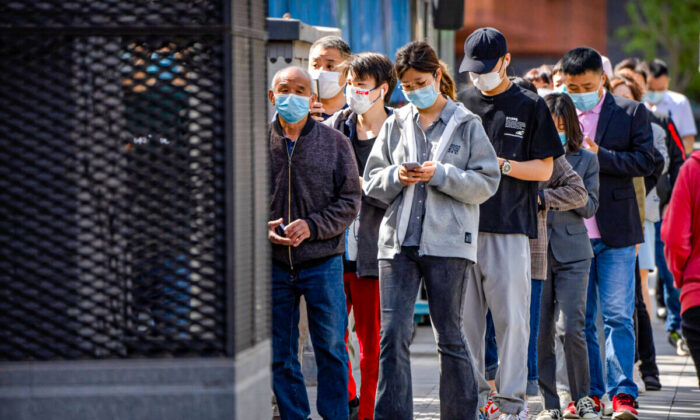People stand in line for coronavirus tests in a neighborhood in the Dongcheng district of Beijing on April 26, 2022. (Mark Schiefelbein/AP Photo)