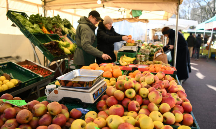 Shoppers peruse a fruit and vegetable stand at a weekly market in Berlin on March 14, 2020. (Annegret Hilse/Reuters)