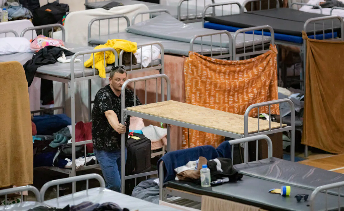 A Ukrainian refugee stands near bunk beds in the Benito Juarez Sports Complex of Tijuana, Mexico, on April 27, 2022. (John Fredricks/The Epoch Times)