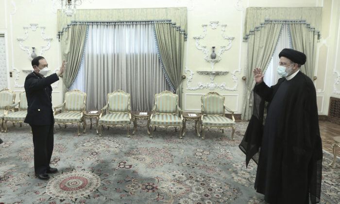 President Ebrahim Raisi (R) and China's minister of national defense, Wei Fenghe (L) greet at the presidency office in Tehran, Iran, on April 27, 2022. (Iranian Presidency Office via AP)