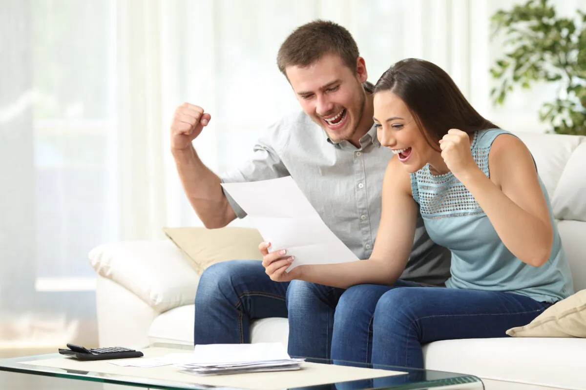 A young couple is excited when they receive their tax refund. (Antonio Guillem/Shutterstock)
