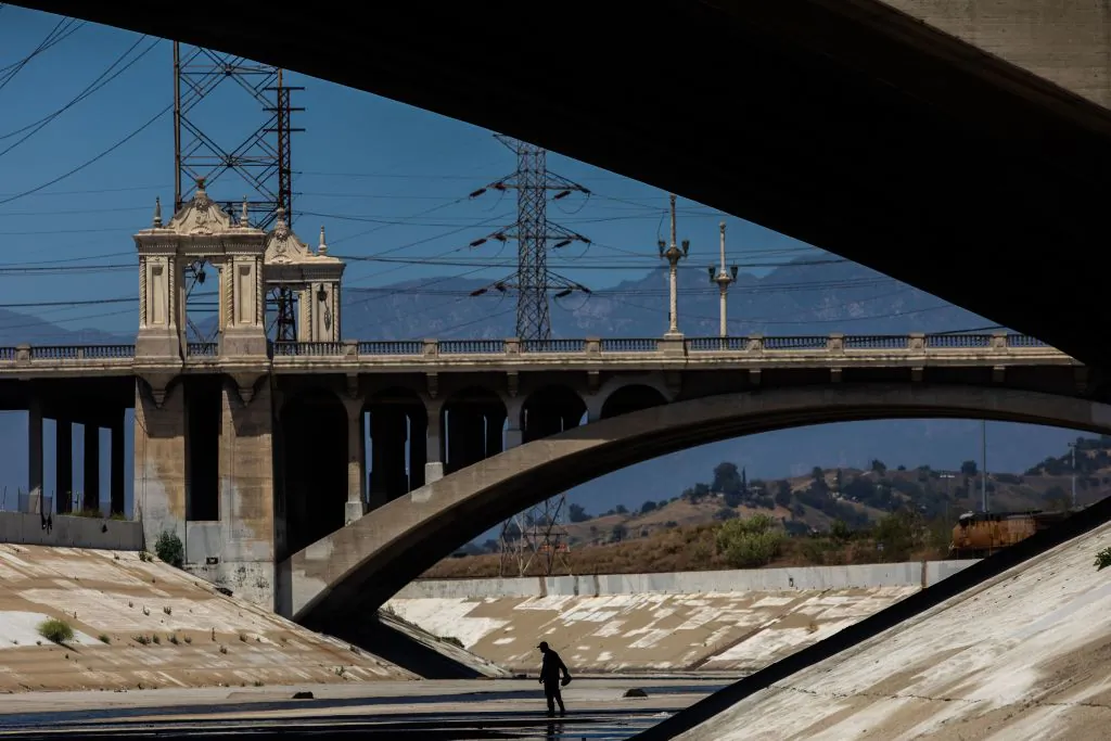 A homeless man walks along the concrete banks of the Los Angeles River during the COVID-19 pandemic in Los Angeles on May 25, 2020. (Apu Gomes/AFP via Getty Images)