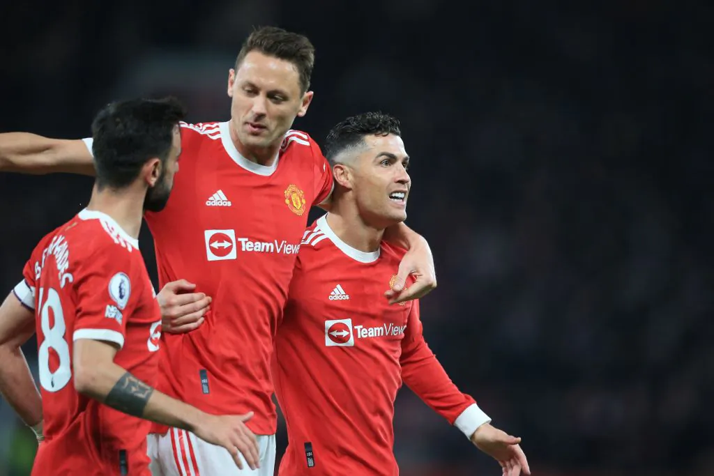 Manchester United striker Cristiano Ronaldo (R) celebrates with midfielder Nemanja Matic (C) and midfielder Bruno Fernandes (L) after scoring their first goal during the English Premier League football match between Manchester United and Chelsea at Old Trafford in Manchester, north west England, on April 28, 2022. (Photo by LINDSEY PARNABY/AFP via Getty Images)