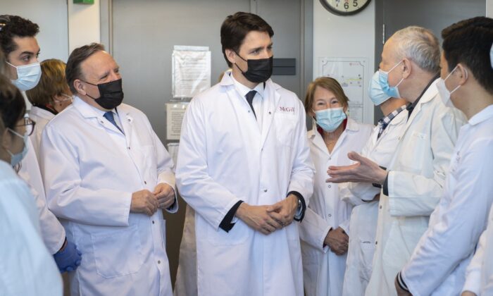 Prime Minister Justin Trudeau, right, and Quebec Premier François Legault, left, tour a research lab at McGill University before an announcement of the opening of a Moderna vaccine production and research facility in Montreal, April 29, 2022. (The Canadian Press/Graham Hughes)