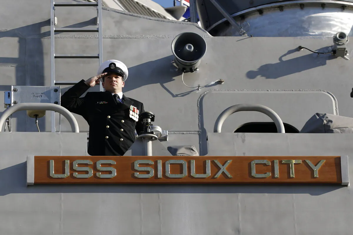 A member of the USS Sioux City salutes from the Freedom class of littoral combat ship, during the ship's commissioning ceremony on Nov. 17, 2018, at the U.S. Naval Academy in Annapolis, Md. (AP Photo/Patrick Semansky, File)