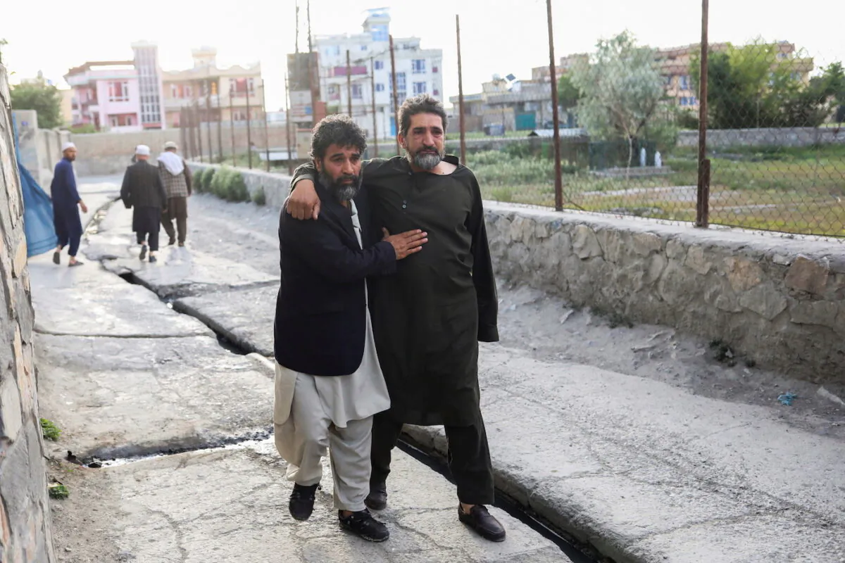 Afghan men flee near the site of explosions at Khalifa Sahib Mosque in Kabul, Afghanistan April 29, 2022. (Ali Khara/Reuters)