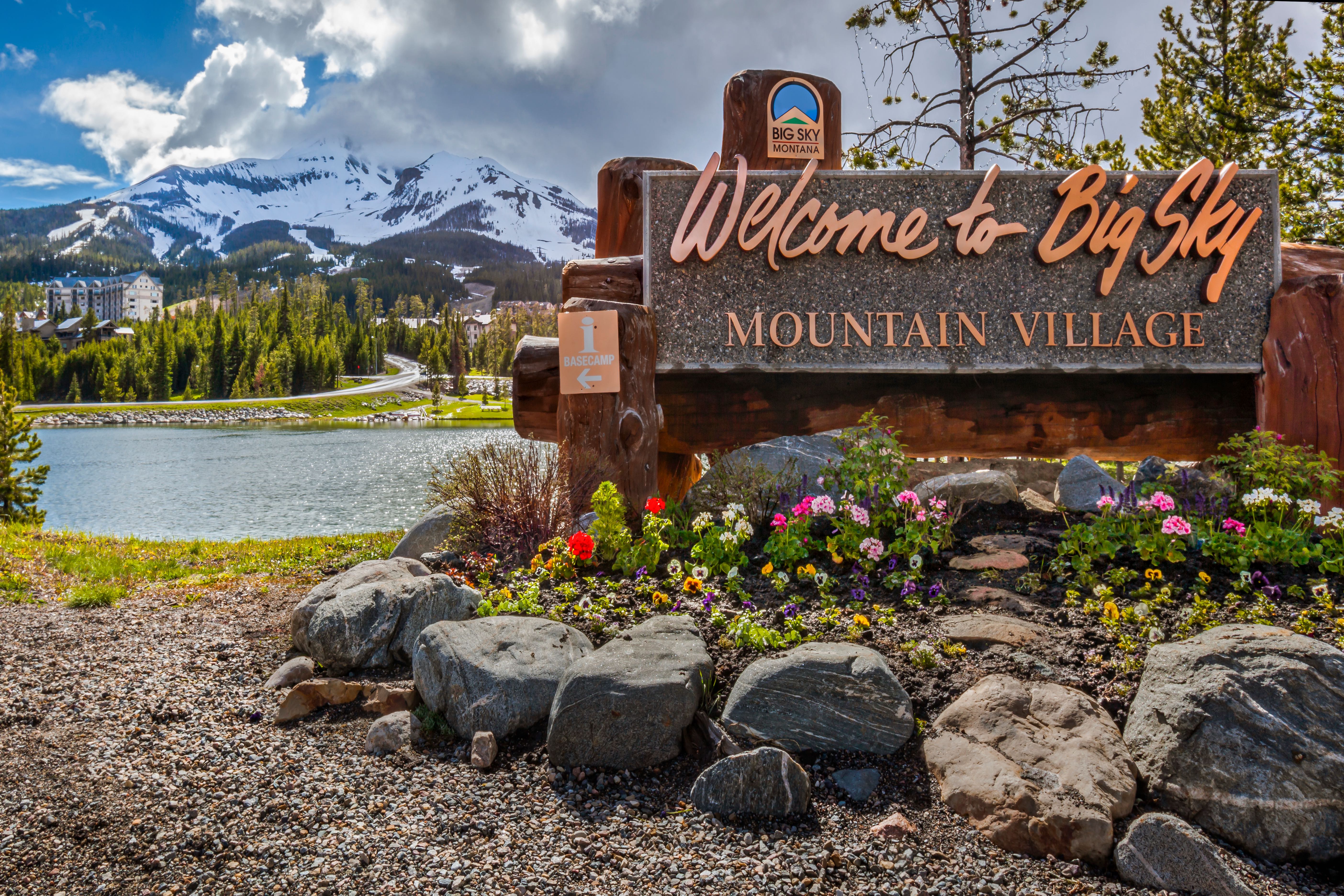 Welcome to Big Sky Mountain Village Signage, Lone Mountain background full of snow in the Madison Range in the state of Montana USA.