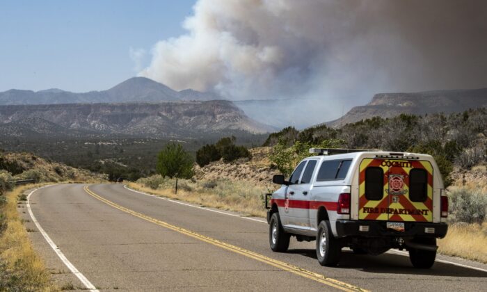 2022 年 4 月 29 日，Cochiti 消防局的车辆驶向新墨西哥州 Cochiti 的 Jemez 山脉燃烧的 Cerro Pelado 大火中冒出的浓烟。（Robert Browman//《阿尔伯克基日报》通过美联社）