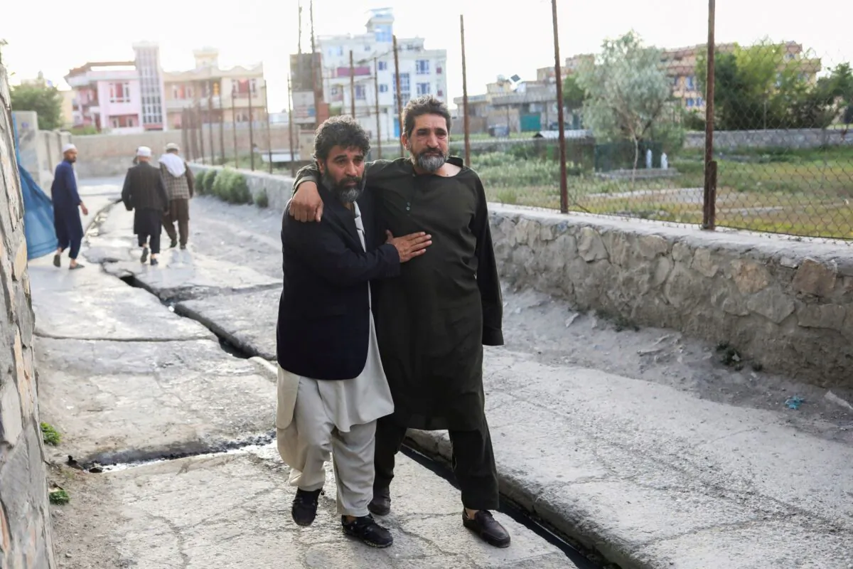 Afghan men flee near the site of explosions at Khalifa Sahib Mosque in Kabul, Afghanistan, on April 29, 2022. (Ali Khara/Reuters)