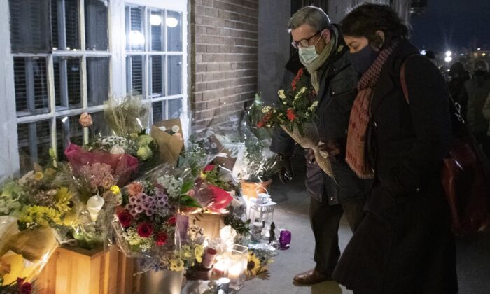 Quebec City mayor Régis Labeaume brings flowers at a vigil to honour Suzanne Clermont, who was stabbed to death on Halloween night by a man with a sword, Nov. 2, 2020 in Quebec City. (The Canadian Press/Jacques Boissinot)