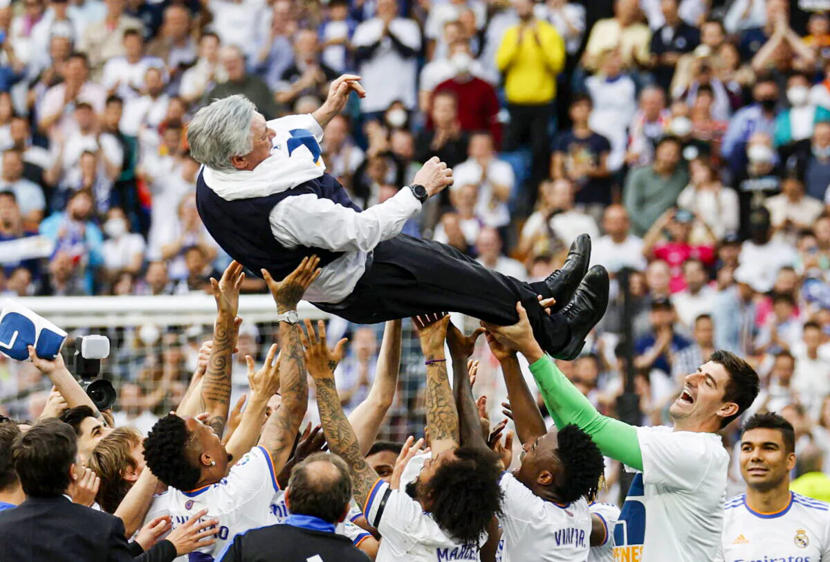 Real Madrid team members lift coach Carlo Ancelotti in the air and celebrate after winning LaLiga, in Madrid, Spain, on April 30, 2022. (Susana Vera/Reuters)