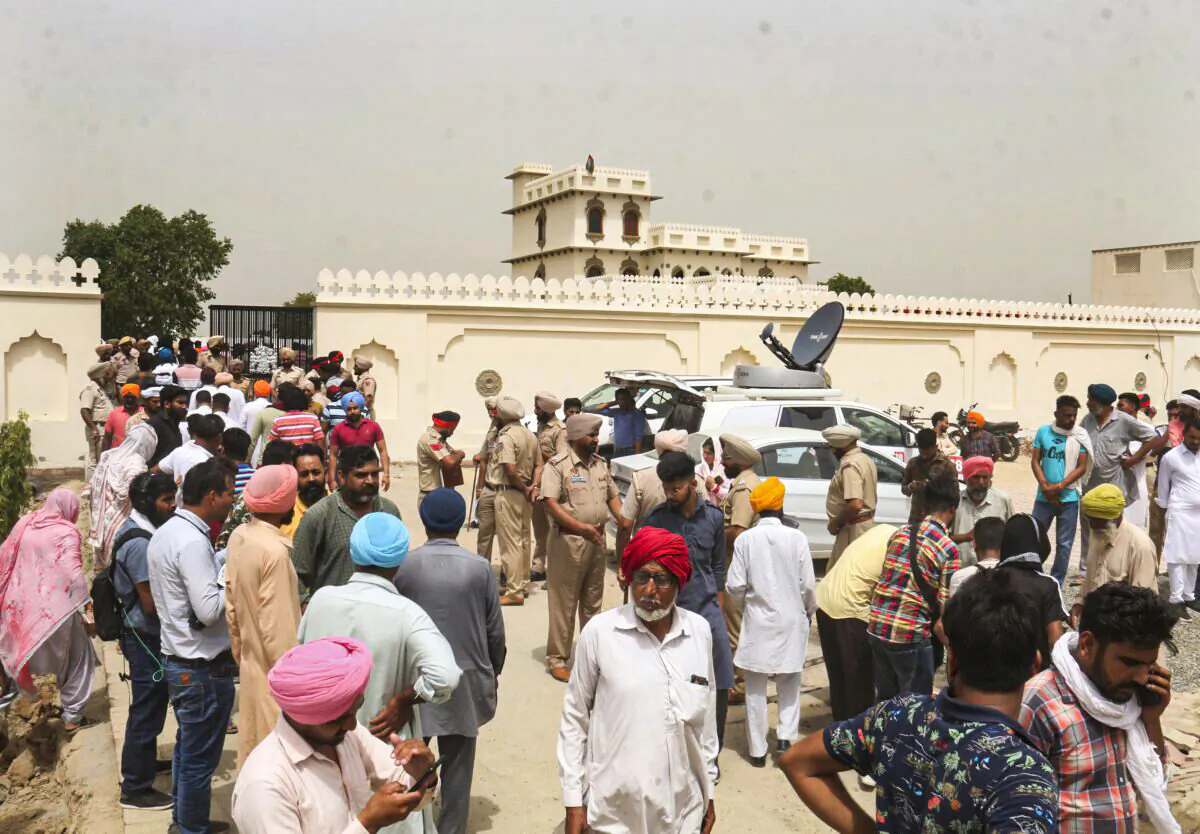 Villagers gather outside the residence of Shubhdeep Singh Sidhu, also known around the world by his stage name Sidhu Moose Wala, in Musa village, near in Mansa, Punjab state, India, on May 30, 2022. (AP Photo)