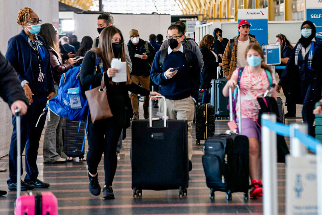 Travelers walk through Ronald Reagan Washington National Airport in Arlington, Va., on April 19, 2022. (Stefani Reynolds/AFP via Getty Images)