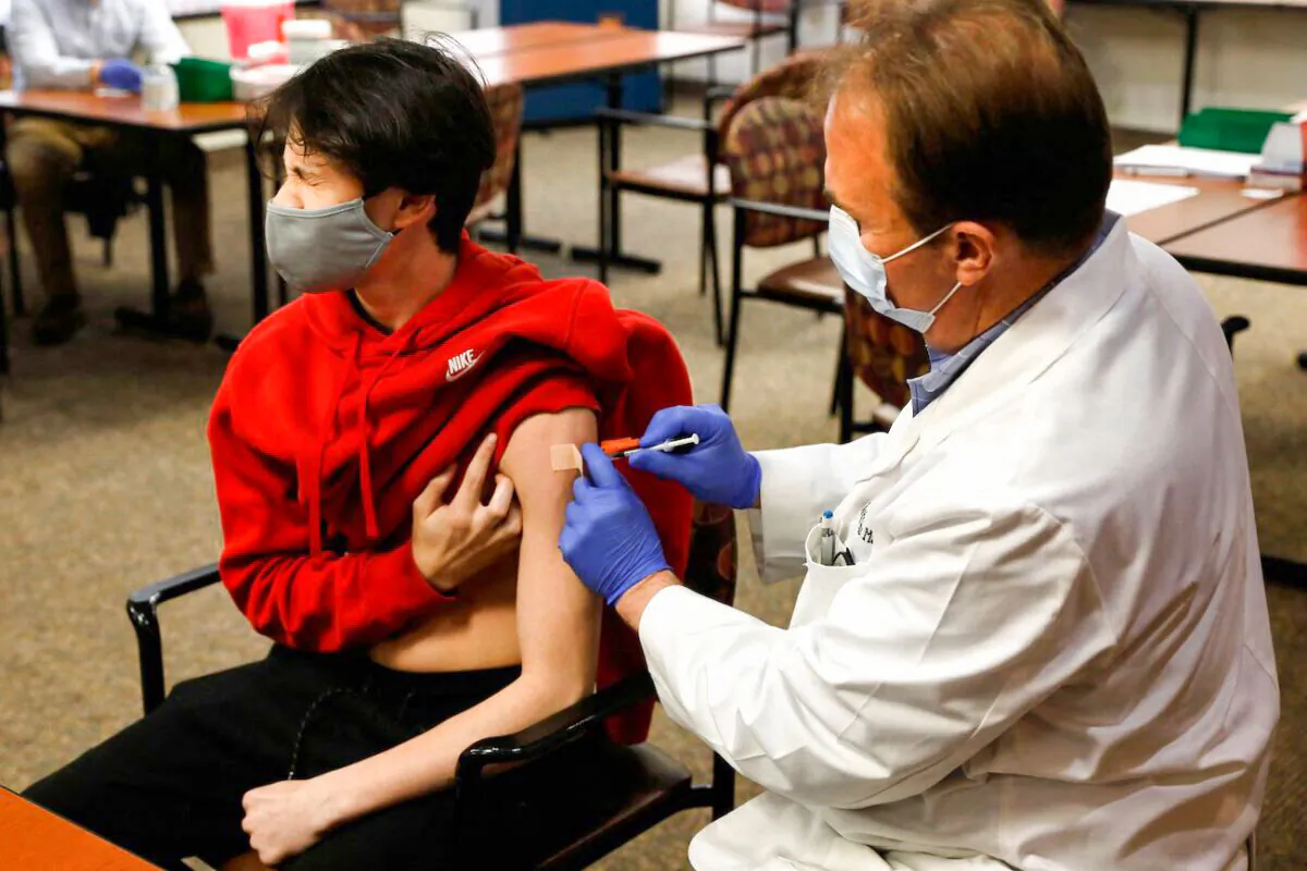 A 15-year-old receives the Pfizer-BioNTech vaccine against the CCP virus in Bloomfield Hills, Mich., on May 13, 2021. (Jeff Kowalsky/AFP via Getty Images)