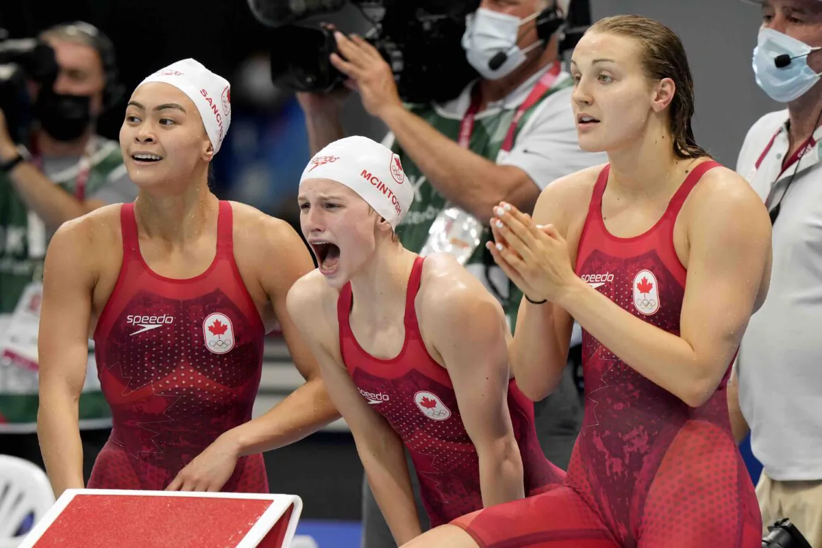 Members of Canada's women swimming team cheer on their teammate during the women's 4x200m swimming final event at the Tokyo Summer Olympic Games on July 29, 2021. (The Canadian Press/Frank Gunn)