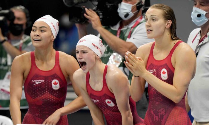 Members of Canada's women swimming team cheer on their teammate during the women's 4x200m swimming final event at the Tokyo Summer Olympic Games on July 29, 2021. (The Canadian Press/Frank Gunn)