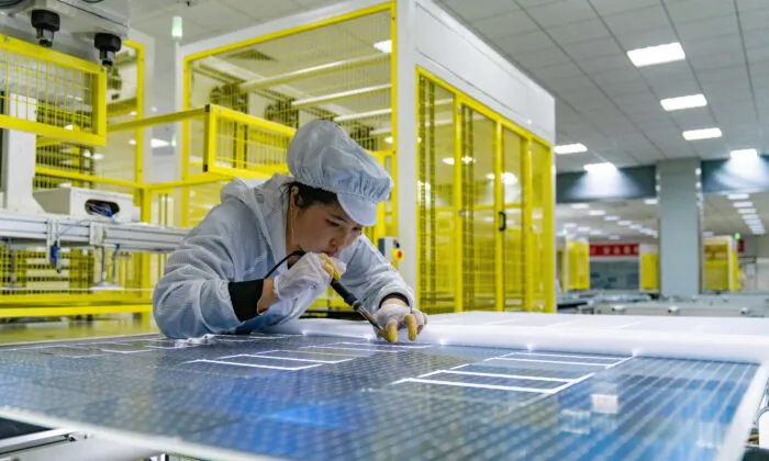 An employee works on the production of solar panels at a factory of GCL (Group) Holding Co., Ltd, in Hefei, Anhui province, China on Jan. 5, 2022. (Photo by Ruan Xuefeng/VCG via Getty Images)