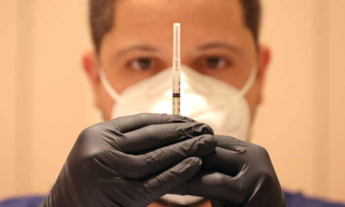 A man fills syringes with COVID-19 vaccine booster shots at a COVID-19 vaccination clinic in San Rafael, Calif., on April 6, 2022. (Justin Sullivan/Getty Images)