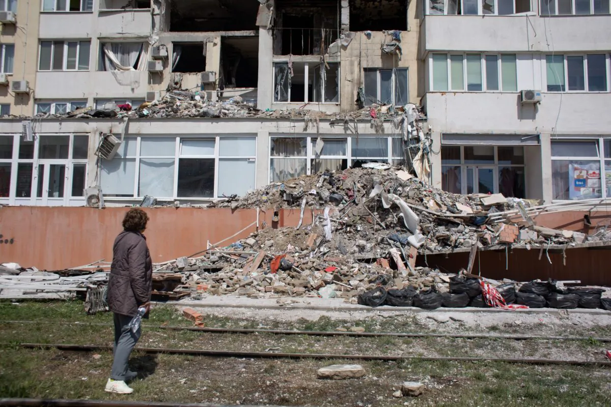 A resident whose apartment got destroyed as a result of a missile strike on a residential building, looks at the work of the rescue team in Odessa, Ukraine, on April 25, 2022. (Anastasia Vlasova/Getty Images)