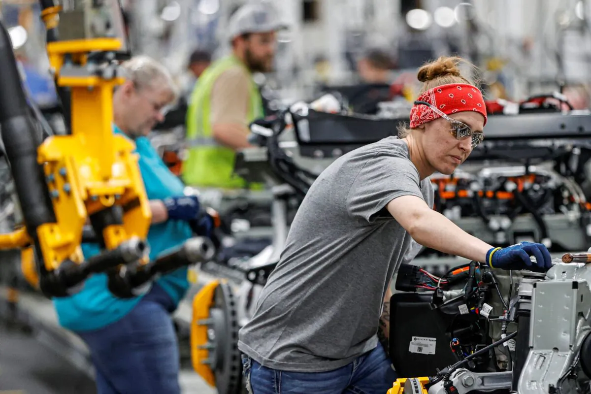 An employee works on an assembly line at startup Rivian Automotive's electric vehicle factory in Normal, Ill., on April 11, 2022. (Kamil Krzaczynski/Reuters)