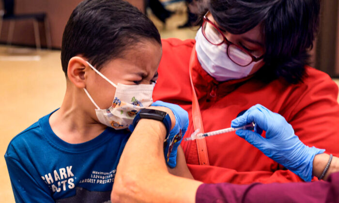 A first grade student, 6-year-old Leonel Campos, receives a COVID-19 vaccine at Arturo Velasquez Institute in Chicago, Ill., on Nov. 12, 2021. (Scott Olson/Getty Images)