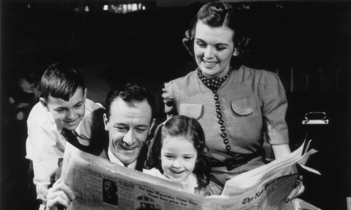 A family gathers around the newspaper for a good laugh, circa 1935. (FPG/Hulton Archive/Getty Images)