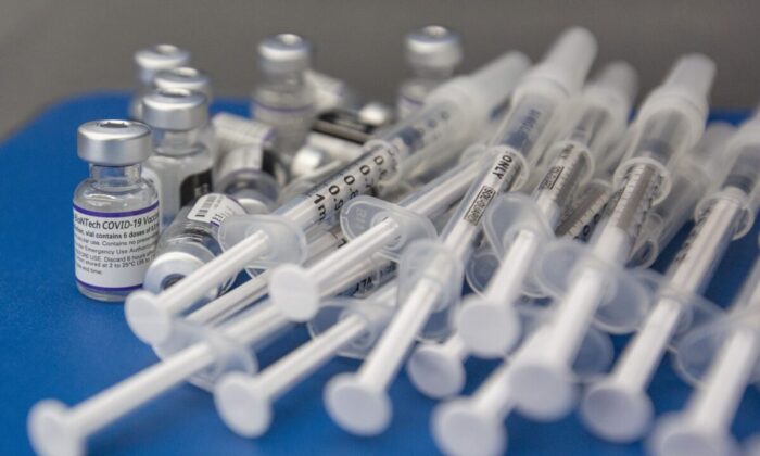Syringes and vials of Pfizer-BioNTech COVID-19 vaccine are seen on a work surface during a drive-through clinic at St. Lawrence College in Kingston, Ont., on Dec. 18, 2021. (The Canadian Press/Lars Hagberg)