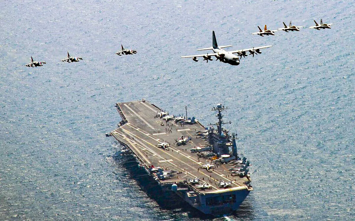 A U.S. Marine Corps C-130 Hercules aircraft leads a formation of F/A-18C Hornet strike fighters and A/V-8B Harrier jets over the aircraft carrier USS George Washington off the coast of South Korea on July 27, 2010. (Mass Communication Specialist 3rd Class Charles Oki/U.S. Navy via Getty Images)