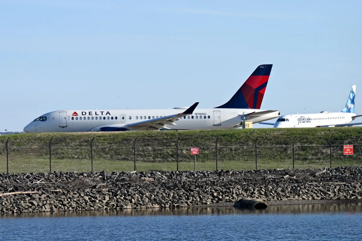 A Delta Airlines plane (L) and a JetBlue Airlines plane wait to take off from Ronald Reagan Washington National Airport in Arlington, Va., on April 2, 2022. (Daniel Slim/AFP via Getty Images)