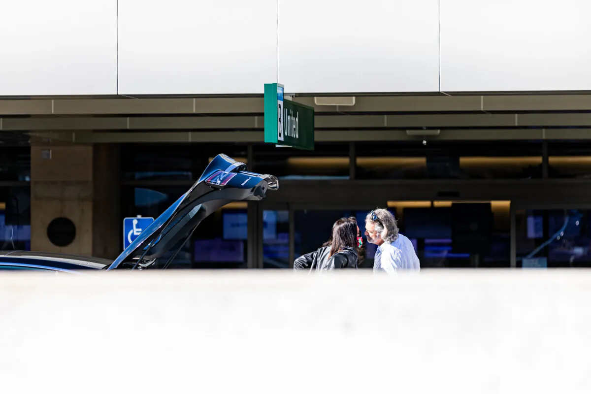 A man and woman kiss goodbye at John Wayne Airport, in Santa Ana, Calif., on Dec. 30, 2020. (John Fredricks/The Epoch Times)