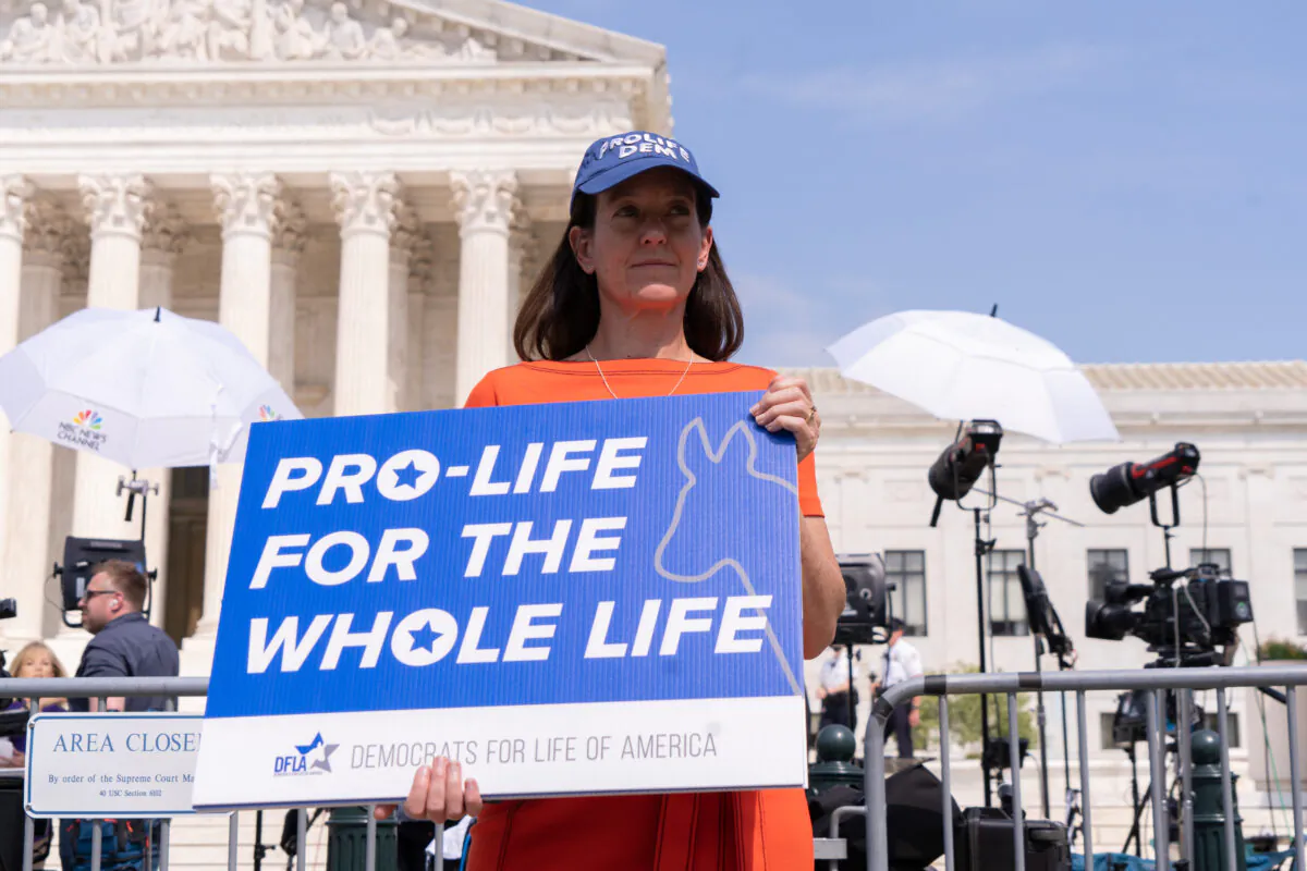 Activists protest in response to the leaked Supreme Court draft decision to overturn Roe v. Wade in front of the U.S. Supreme Court in Washington, May 3, 2022. (Louis Chen/The Epoch Times)