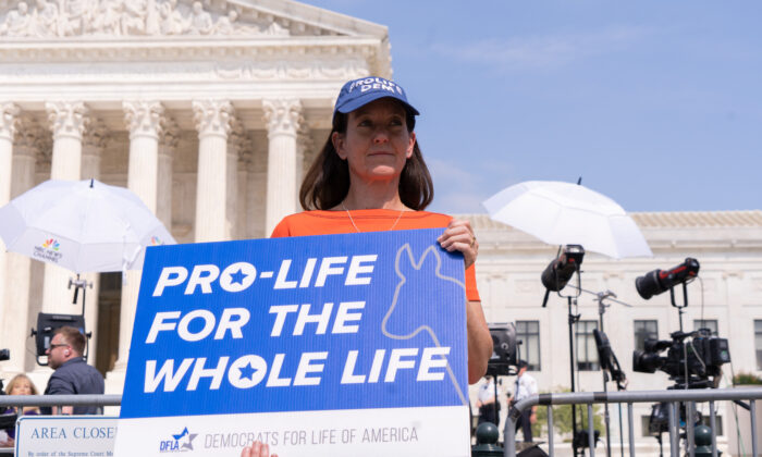 Activists protest in response to the leaked Supreme Court draft decision to overturn Roe v. Wade in front of the U.S. Supreme Court in Washington, May 3, 2022. (Louis Chen/The Epoch Times)