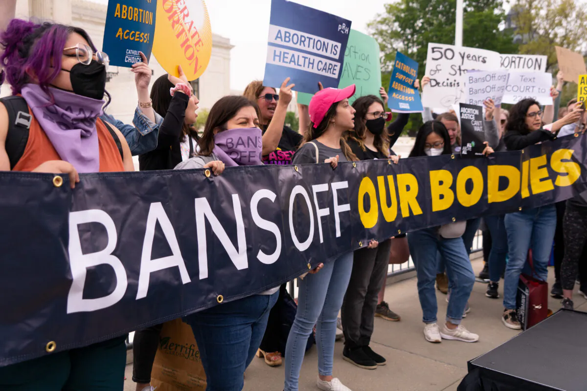 Pro-abortion activists protest in response to the leaked Supreme Court draft decision to overturn Roe v. Wade in front of the U.S. Supreme Court in Washington, May 3, 2022. (Louis Chen/The Epoch Times)