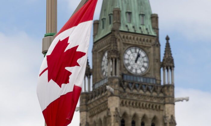 A Canadian flag hangs from a lamp post along the road in front of the Parliament buildings in Ottawa, June 30, 2020. (The Canadian Press/Adrian Wyld)