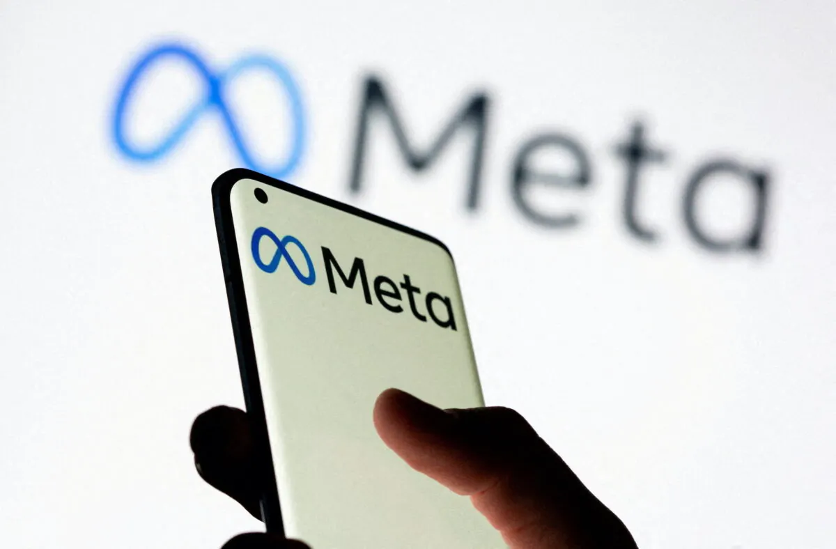 A woman holds a smartphone with the Meta logo in an illustration image. (Dado Ruvic/Reuters)