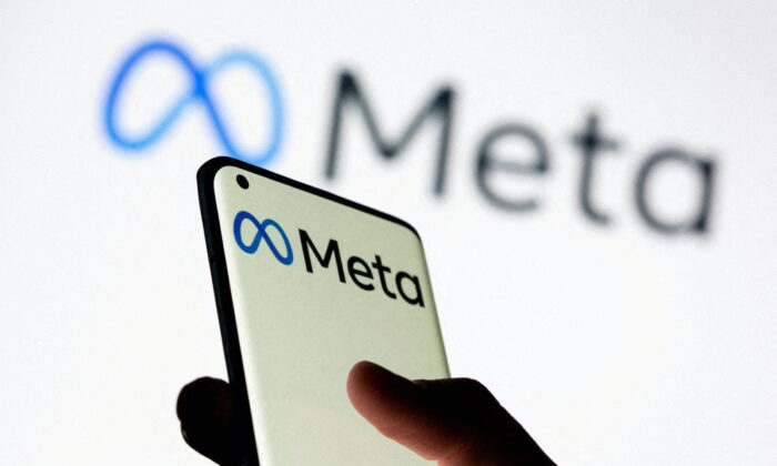 A woman holds a smartphone with the Meta logo in front of a displayed Facebook's new rebrand logo Meta in this illustration picture taken on Oct. 28, 2021. (Dado Ruvic/Reuters)