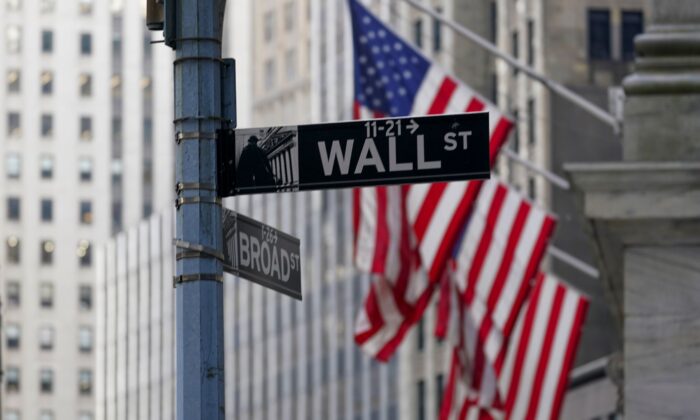 The Wall St. street sign is framed by the American flags flying outside the New York Stock exchange in the Financial District on Jan. 14, 2022. (Mary Altaffer/AP Photo)