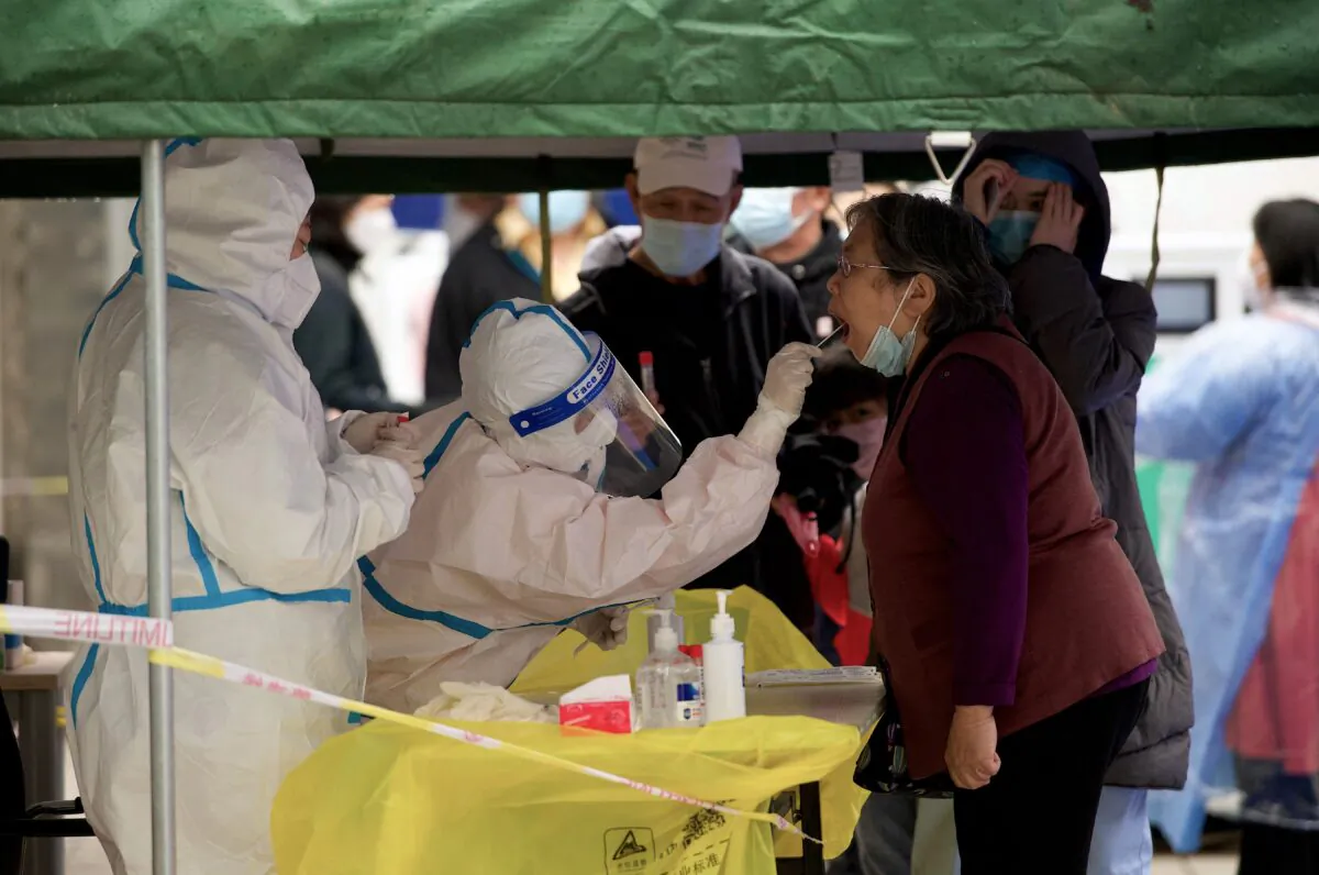 A health worker has a swab sample taken, that will be tested for COVID-19 coronavirus, at a sample collection site in Beijing, China, on April 27, 2022. (Noel Celis/AFP via Getty Images)