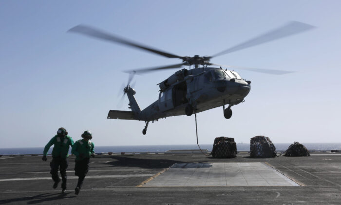 Logistics Specialist 1st Class Ousseinou Kaba (L), from Silver Spring, Md., and Logistics Specialist Seaman Abigail Marshke, from Flint, Mich., attach cargo to an MH-60S Sea Hawk helicopter from the "Nightdippers" of Helicopter Sea Combat Squadron (HSC) 5 from the flight deck of the Nimitz-class aircraft carrier USS Abraham Lincoln (CVN 72) in the Red Sea, on May 10, 2019. (Mass Communication Specialist 3rd Class Amber Smalley/U.S. Navy via Getty Images)