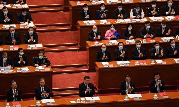 Chinese Communist Party leader Xi Jinping and other leaders applaud during the closing session of the rubber-stamp legislature’s conference at the Great Hall of the People in Beijing on March 11, 2022. (Leo Ramirez/AFP via Getty Images)