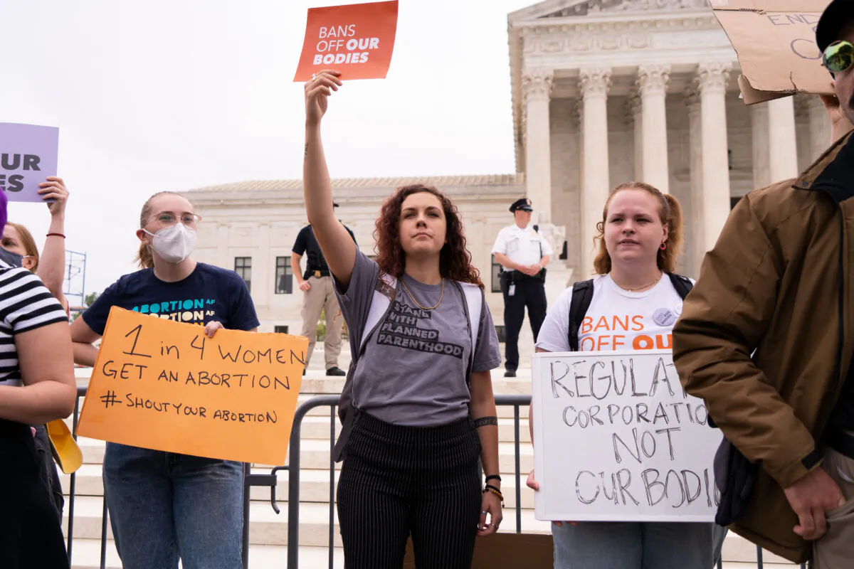 Activists protest in response to the leaked Supreme Court draft decision to overturn Roe v. Wade in front of the U.S. Supreme Court in Washington on May 3, 2022. (Louis Chen/The Epoch Times)