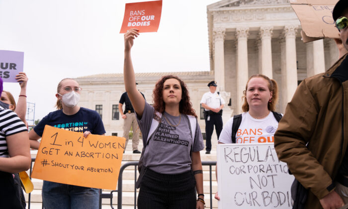 Activists protest in response to the leaked Supreme Court draft decision to overturn Roe v. Wade in front of the U.S. Supreme Court in Washington on May 3, 2022. (Louis Chen/The Epoch Times)