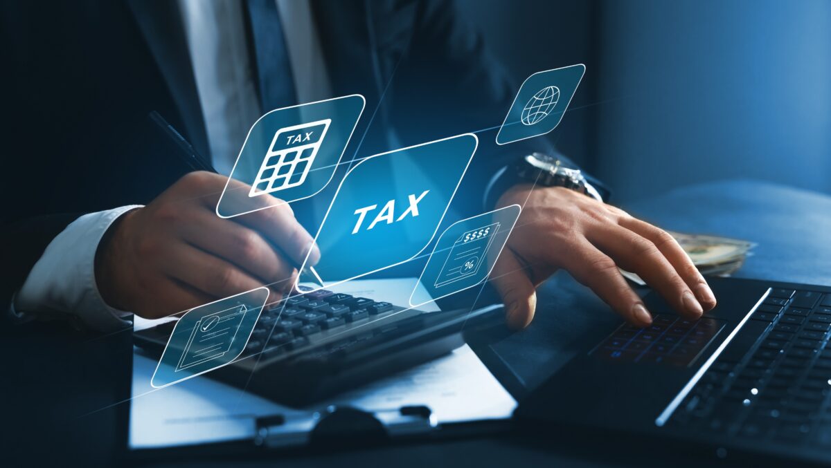 Financial research,government taxes and calculation tax return concept. Businessman using the laptop to fill in the income  tax online return form for payment. (Miha Creative/ShutterStock)
