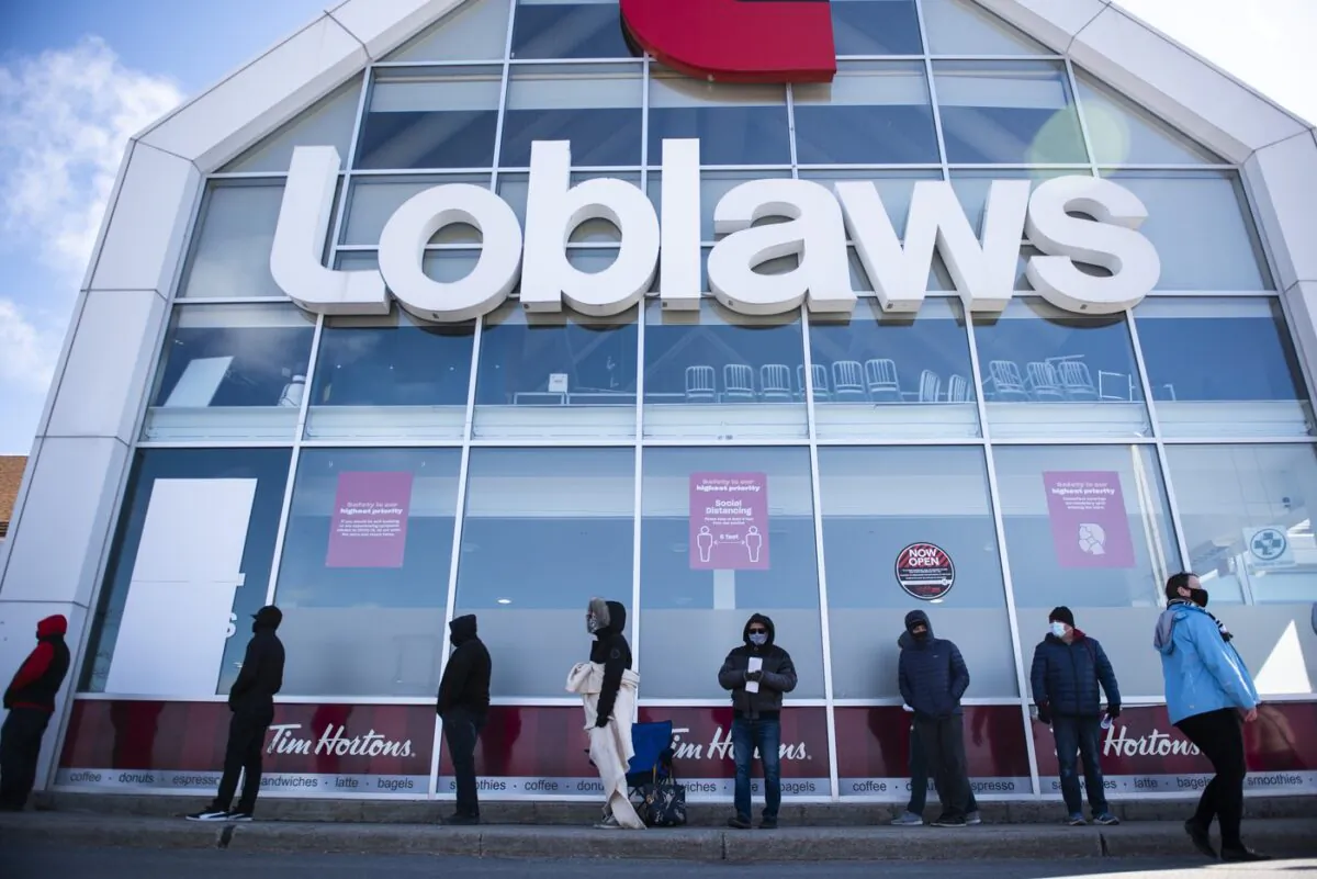 People wait in a line to receive a COVID-19 vaccine at a Loblaws grocery store pharmacy in Ottawa, on April 26, 2021. (The Canadian Press/Justin Tang)