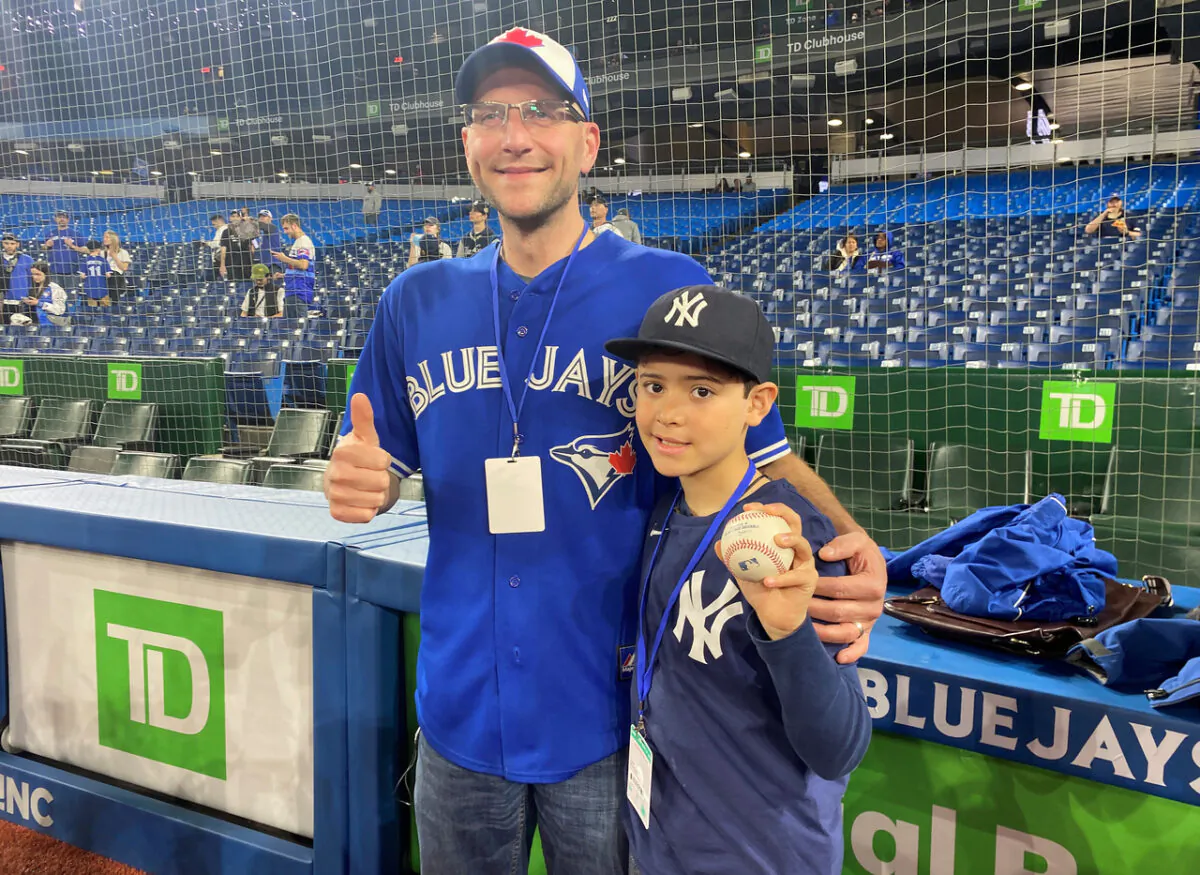 Nine-year-old Derek Rodriguez poses for a photo with Mike Lanzillotta, the Blue Jays fan who caught Aaron Judge's home run ball and handed it to the youngster during a game between  the Toronto Blue Jays and New York Yankees in Toronto on May 4, 2022. (The Canadian Press/Gregory Strong)