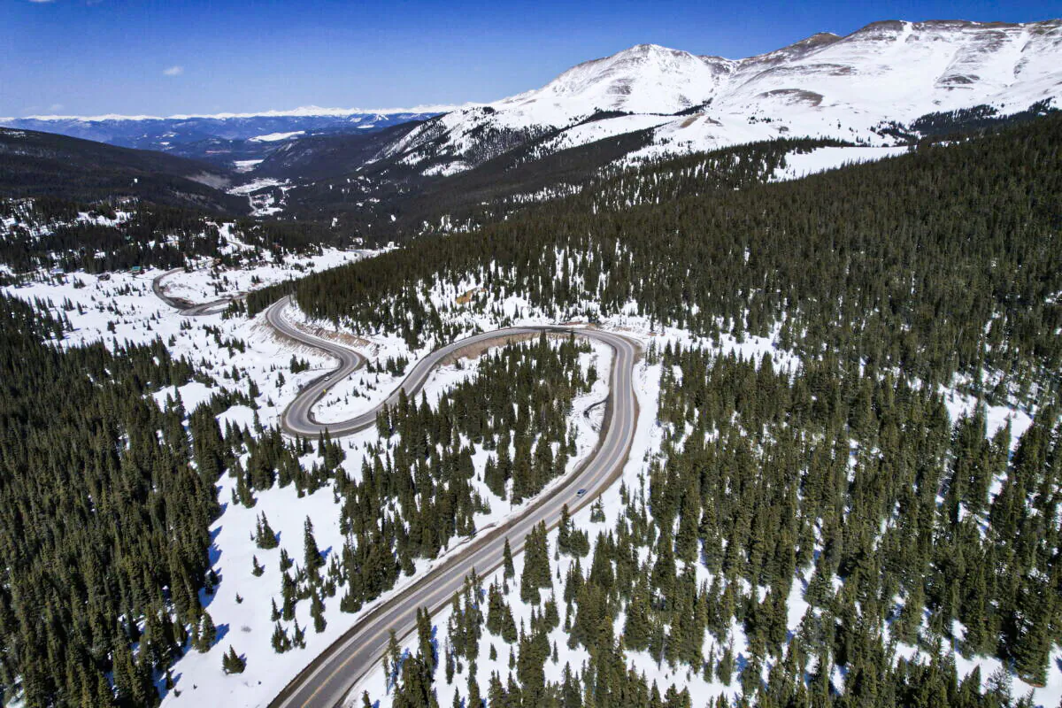 A road winds through the snow-covered Rocky Mountains at Hoosier Pass as seen from the air near Blue River, Colo., on April 18, 2022. (Brittany Peterson/AP Photo)