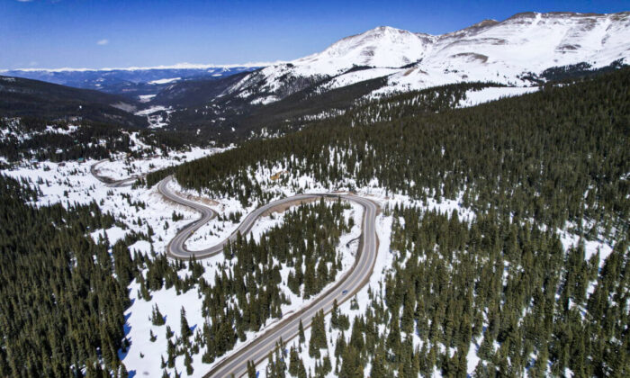 A road winds through the snow-covered Rocky Mountains at Hoosier Pass as seen from the air near Blue River, Colo., on April 18, 2022. (Brittany Peterson/AP Photo)