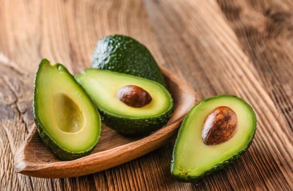 avocado halves in a wooden bowl