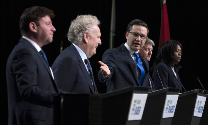 Conservative leadership candidate Pierre Poilievre gestures towards Jean Charest as Roman Baber, left, Scott Aitchison and Leslyn Lewis, right, debate at the Canada Strong and Free Network conference, in Ottawa on May 5, 2022. (Adrian Wyld/The Canadian Press)