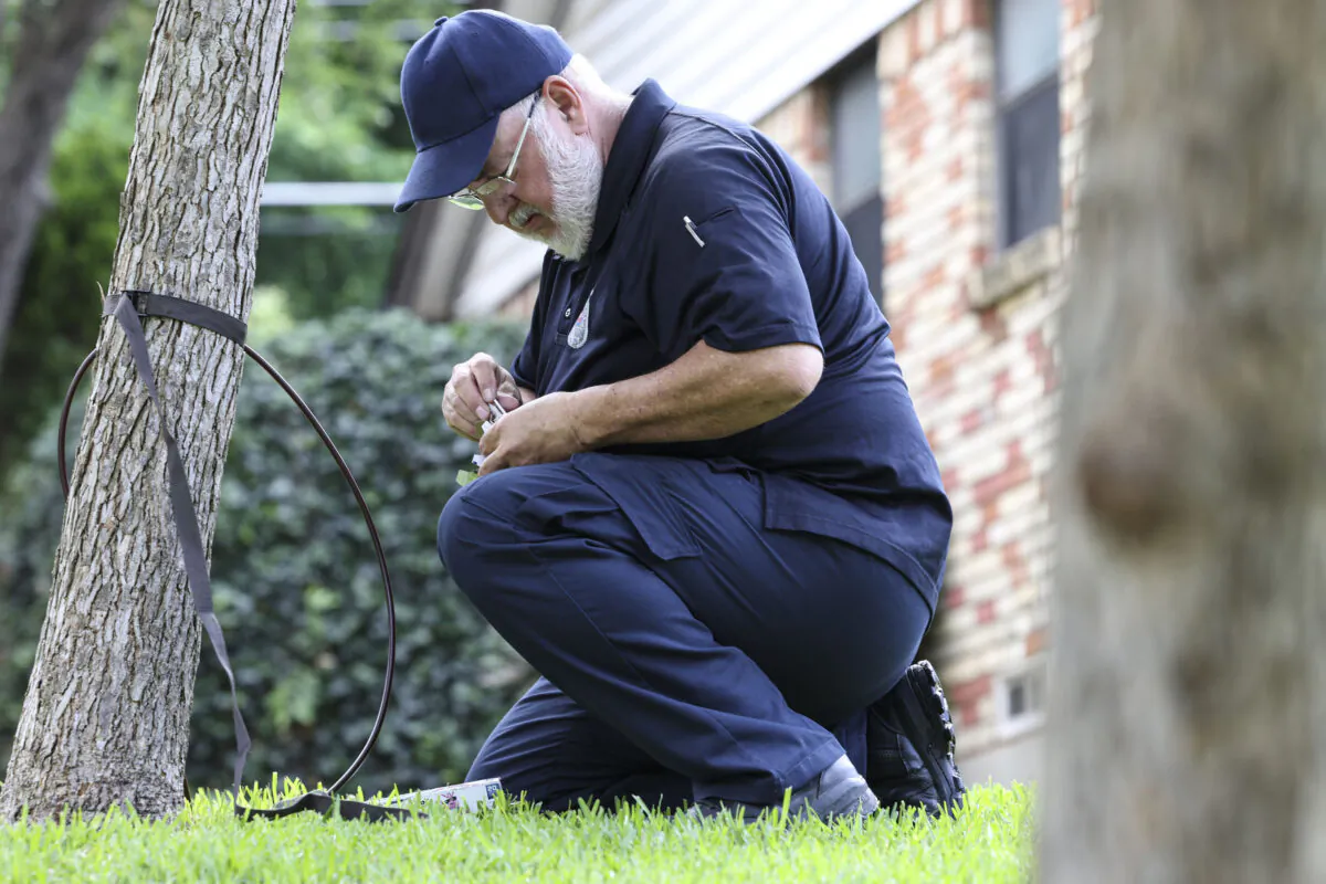 A City of Dallas Animal Service Officer removes a camera from a tree two doors down from where on May 3, 2022 a 2-year-old was attacked by a coyote in Dallas, on May 4, 2022. (Rebecca Slezak/The Dallas Morning News/TNS)